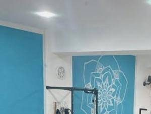 Parede turquesa com mandala e aparelho de pilates no estúdio